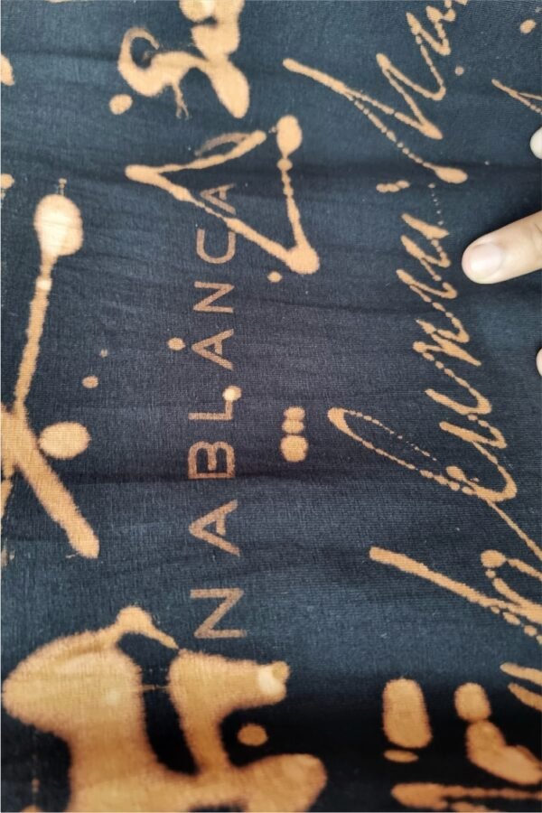 an image of a black t-shirt with copper colored handwriting graphics over it