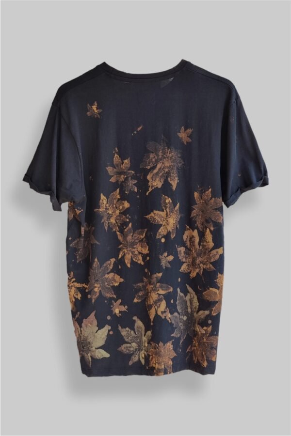 an image of a black t-shirt with copper colored leaf graphics over it