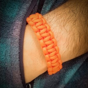 handmade stitched adjustable orange kesari paracord bracelet which resembles Tom Hardy's paracord bracelet from the movie Mad Max Fury Road