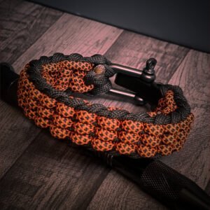 premium handmade track knot paracord bracelet in diamond orange and black paracord with adjustable shackle buckle