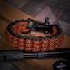 premium handmade track knot paracord bracelet in diamond orange and black paracord with adjustable shackle buckle